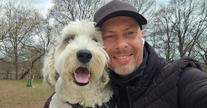 A smiling walker taking a selfie with an equally happy sheepdog mix